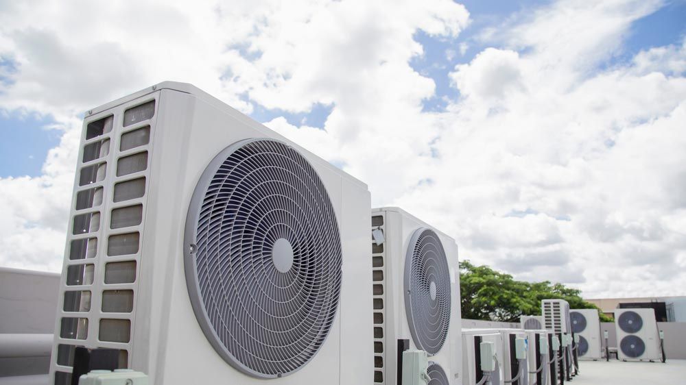 A White Air Conditioning Units Sit on a Rooftop — Premiair Refrigeration, Air Conditioning & Electrical in Tamworth, NSW