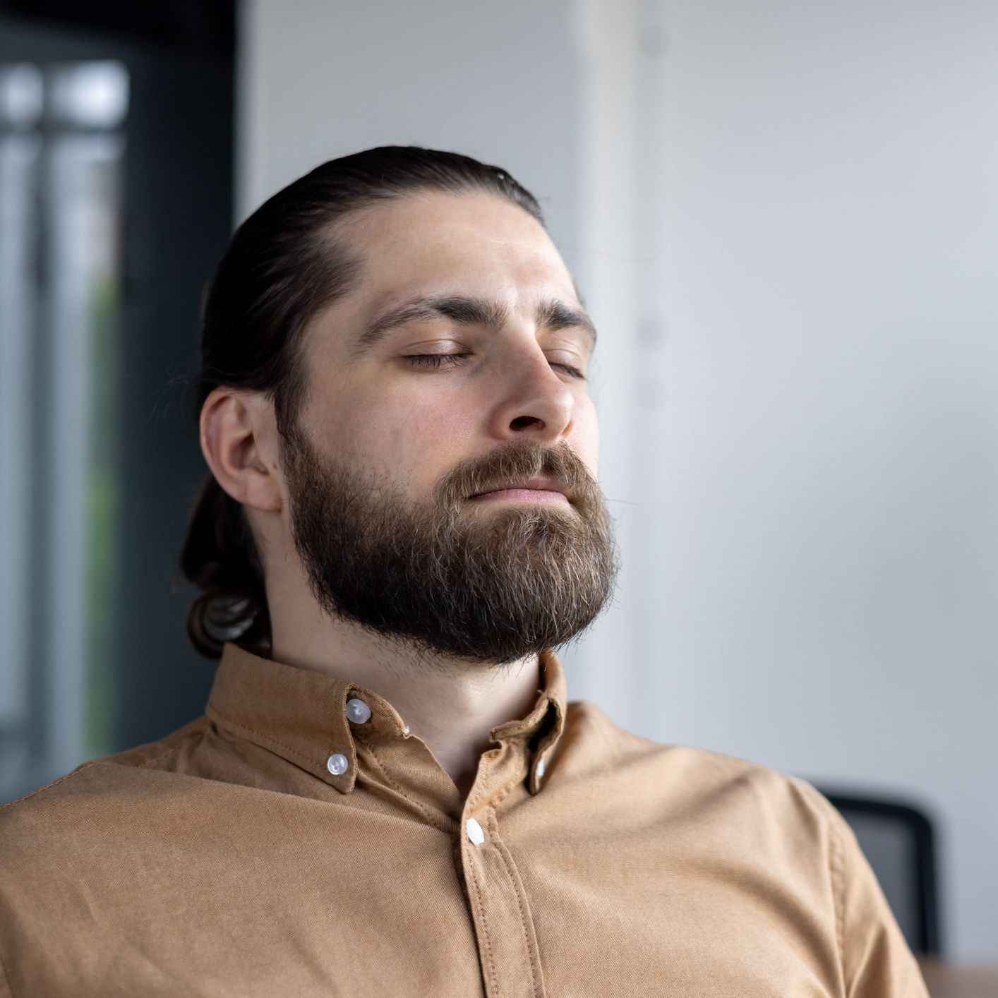 Woman at desk with head in hands, stressed, laptop, notebook, phone.