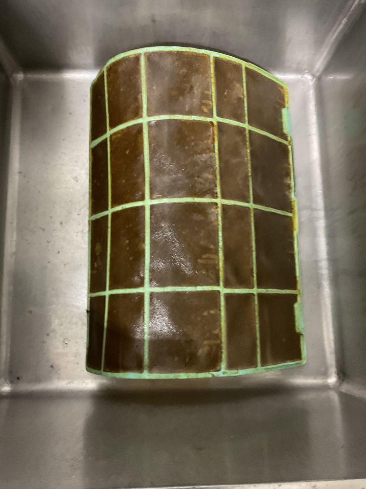 Clogged air conditioner filter being cleaned during regular HVAC maintenance check