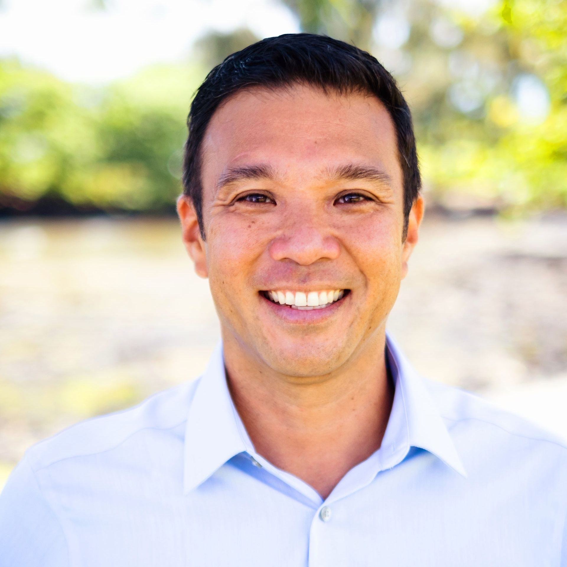 A man in a blue shirt is smiling for the camera.