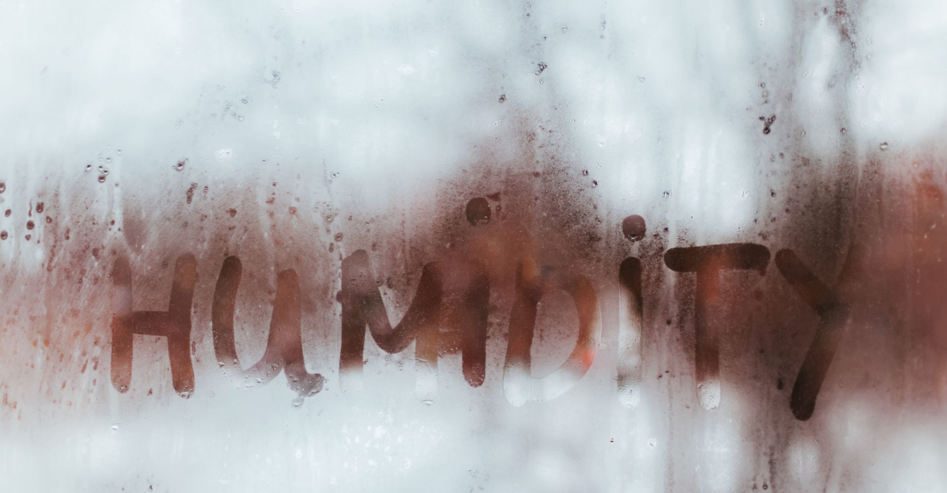 The word humidity is written on a foggy window.