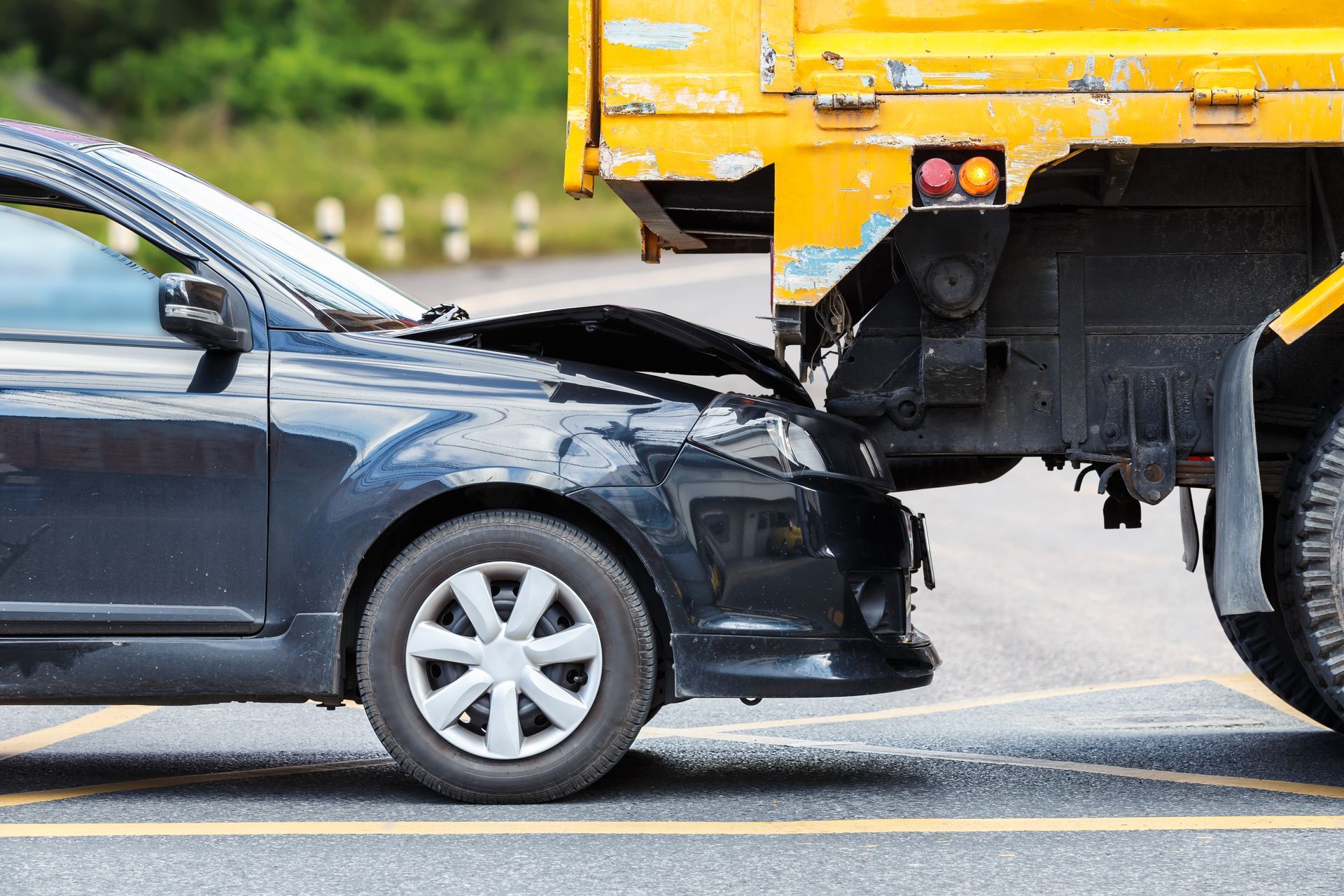 A car is being towed by a yellow truck.