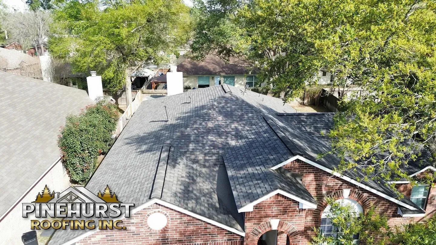 An aerial view of a house with a roof that has been installed by pinehurst roofing inc.