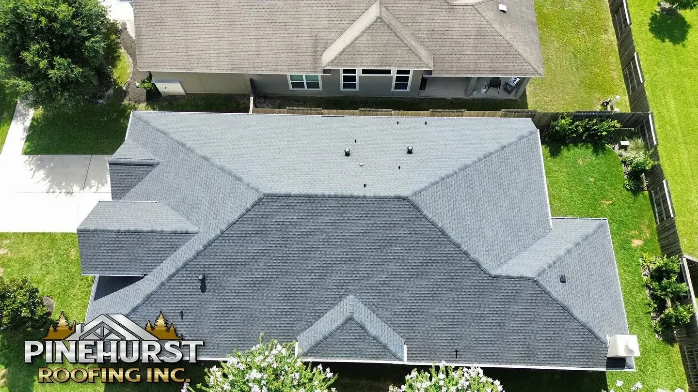An aerial view of a house with pinehurst roofing inc. written on the bottom