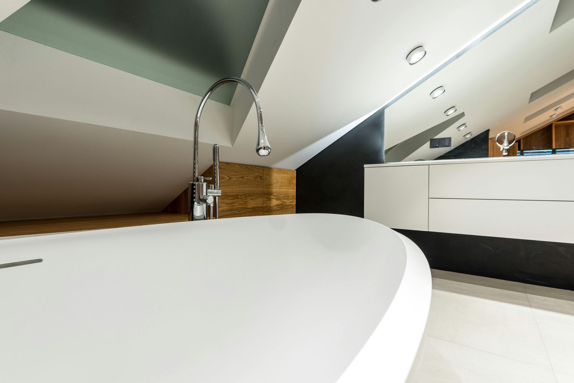 A bathtub in a bathroom with a faucet and a mirror.