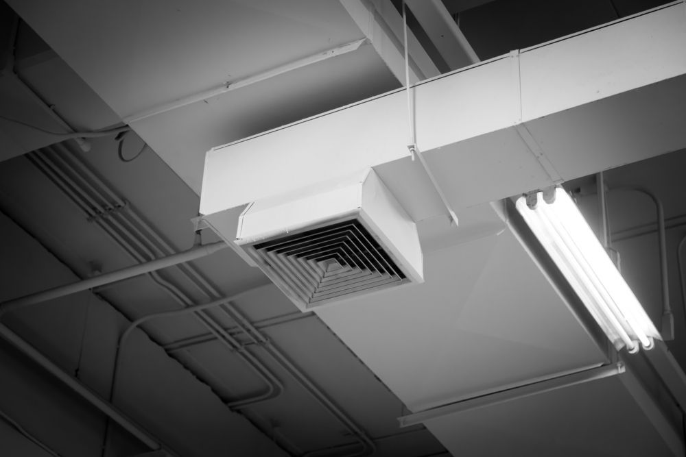 A Black and White Photo of a Ceiling With Ducts and a Light — Enterprise Air That's Cool in Svensson Heights, QLD