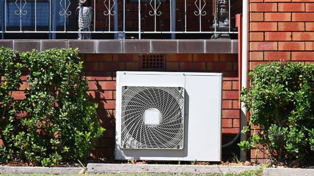 A White Air Conditioner is Sitting on the Side of a Brick Building — Enterprise Air That's Cool in Svensson Heights, QLD