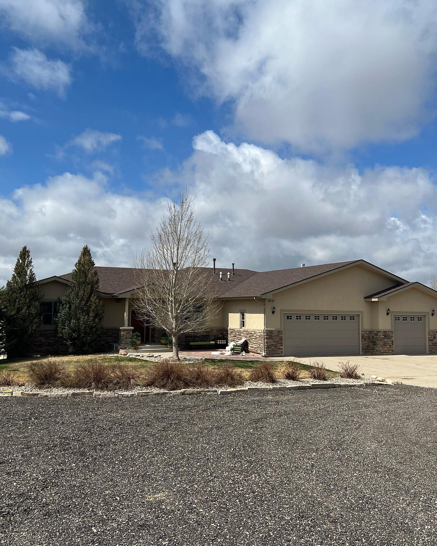 A large house with a lot of garage doors and a tree in front of it.