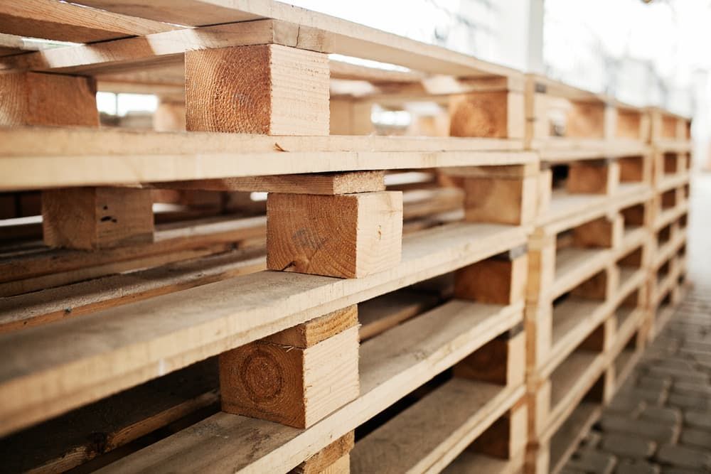 A Row of Wooden Pallets Stacked on Top of Each Other in A Warehouse — Adam's Sawmill in Bonville, NSW