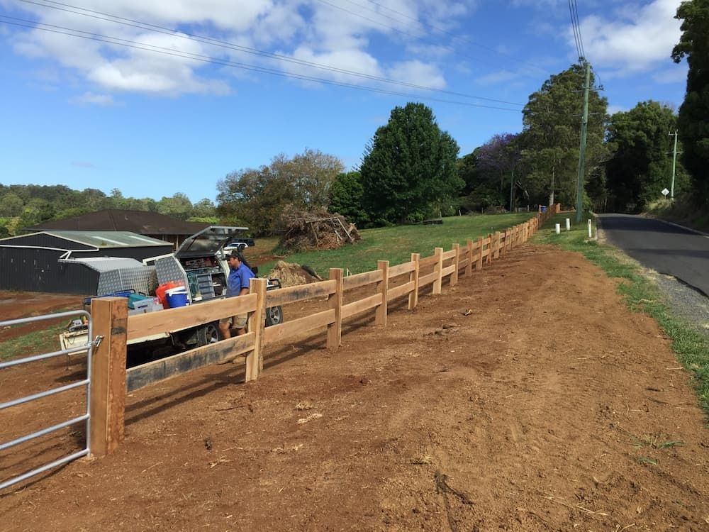 A Wooden Fence Is Being Built Next to A Dirt Road — Adam's Sawmill in Bonville, NSW