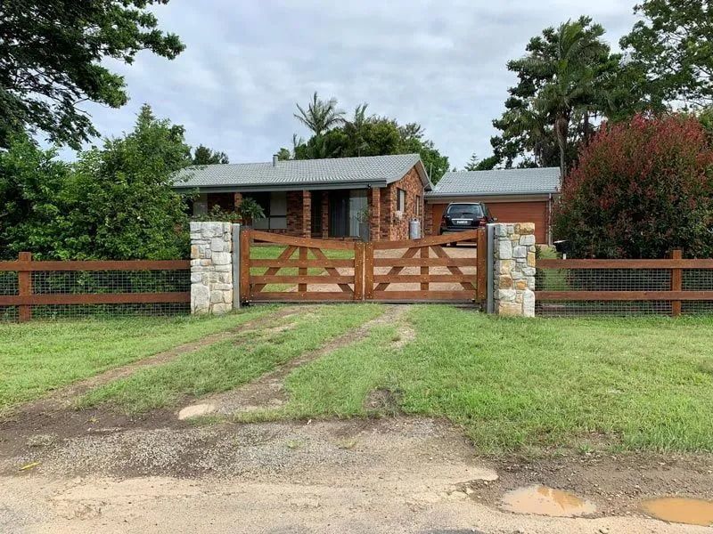 A House with A Wooden Gate in Front of It — Adam's Sawmill in Bonville, NSW
