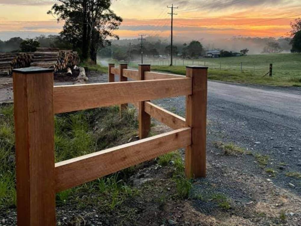 A Wooden Fence Is Sitting on The Side of A Dirt Road — Adam's Sawmill in Bonville, NSW