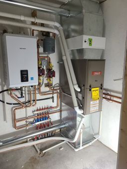 A room with a lot of pipes and a heater.