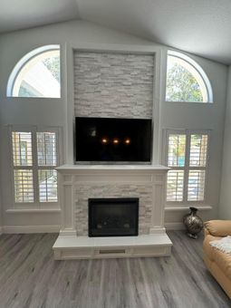 A living room with a fireplace and a flat screen tv above it.