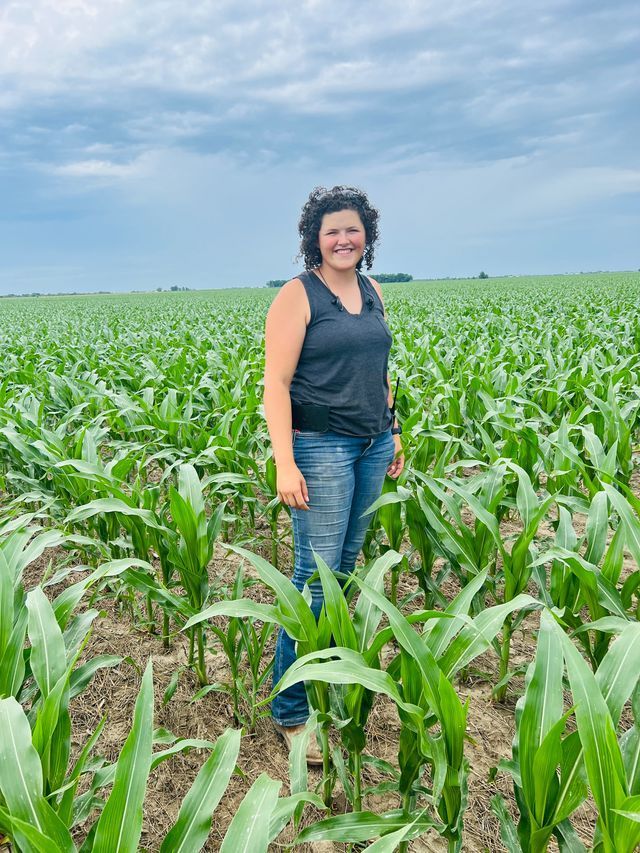 Larna is standing in a cornfield.