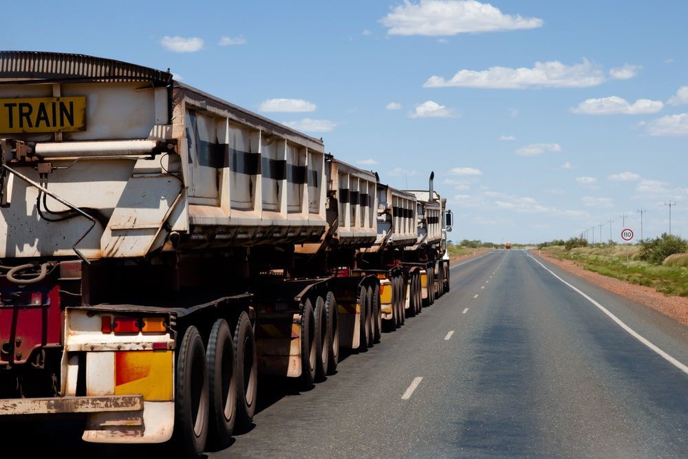 A Large Truck Is Driving Down A Highway — Castledine's Truck Painting & Repairs in Fountaindale, NSW