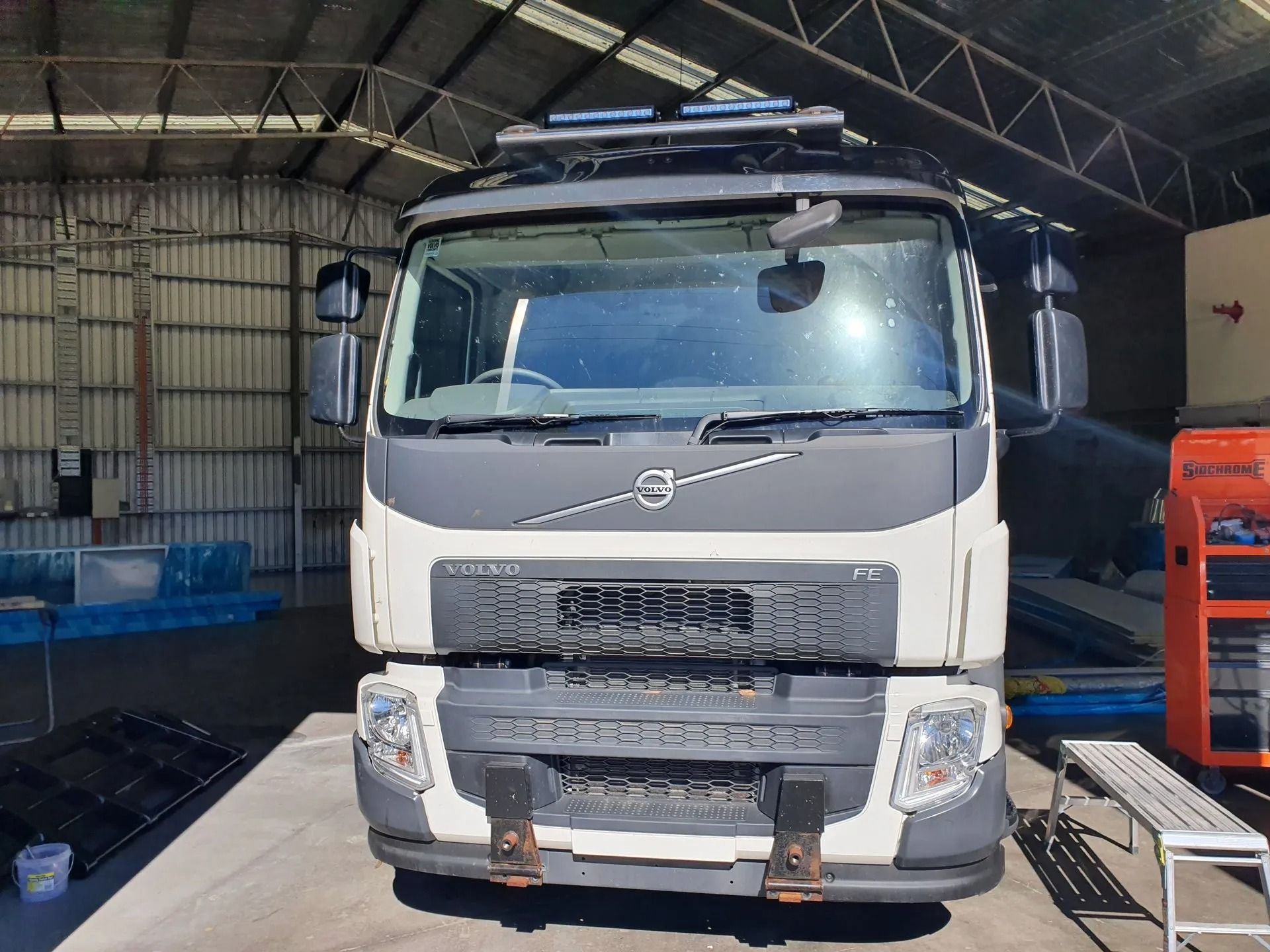 A Truck Parked In A Large Garage  — Castledine's Truck Painting & Repairs in Tuggerah, NSW