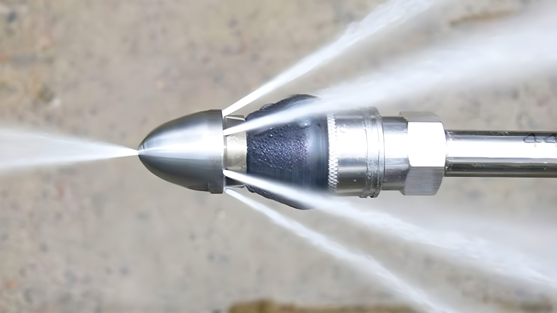 Hydro jet nozzle spraying water, cleaning a concrete surface.