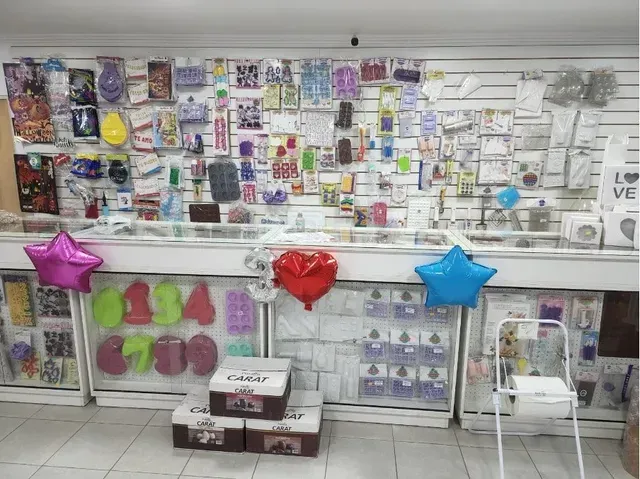Pared con artículos para fiestas y regalos, adornada con coloridos globos, en el escaparate de una tienda.