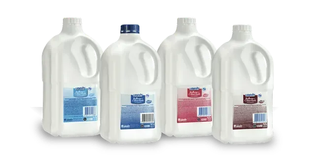 Cuatro jarras de leche de un galón con asas blancas, etiquetadas como azul, azul, rojo y marrón, sobre un fondo blanco.