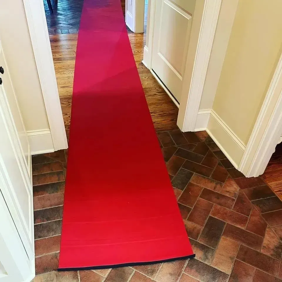 A long red carpet is going down a hallway.