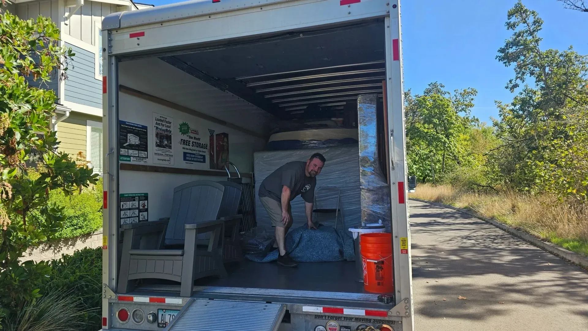 A man is loading furniture into a moving truck.