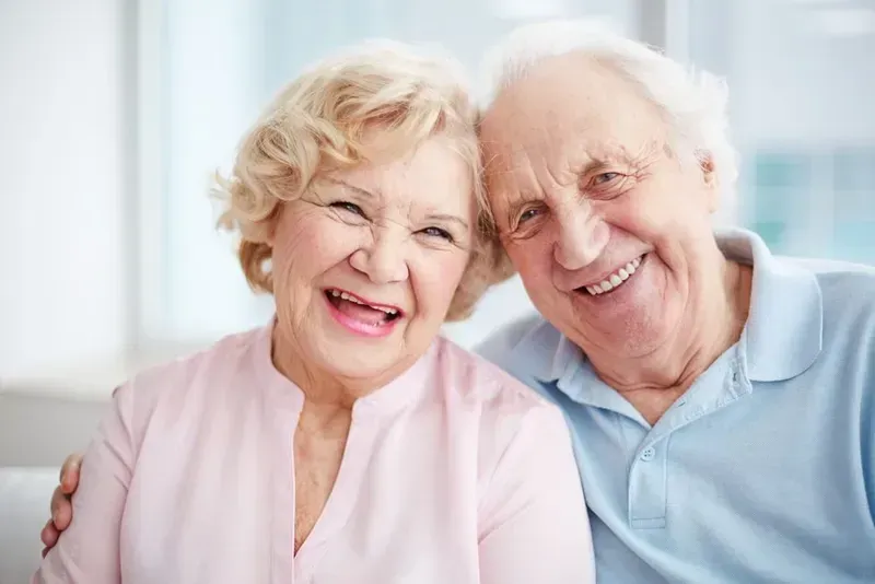 An Elderly Couple is Smiling for the Camera — Twin Towns Denture Clinic In Forster, NSW