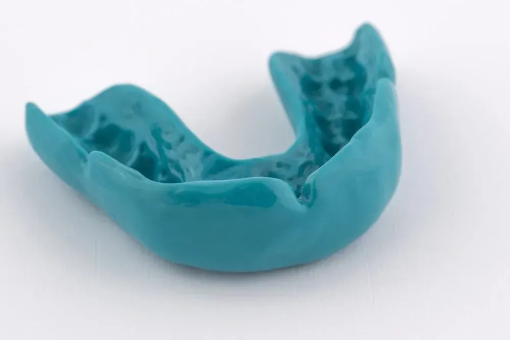 A Blue Mouth Guard is Sitting on a White Surface — Twin Towns Denture Clinic In Tea Gardens, NSW