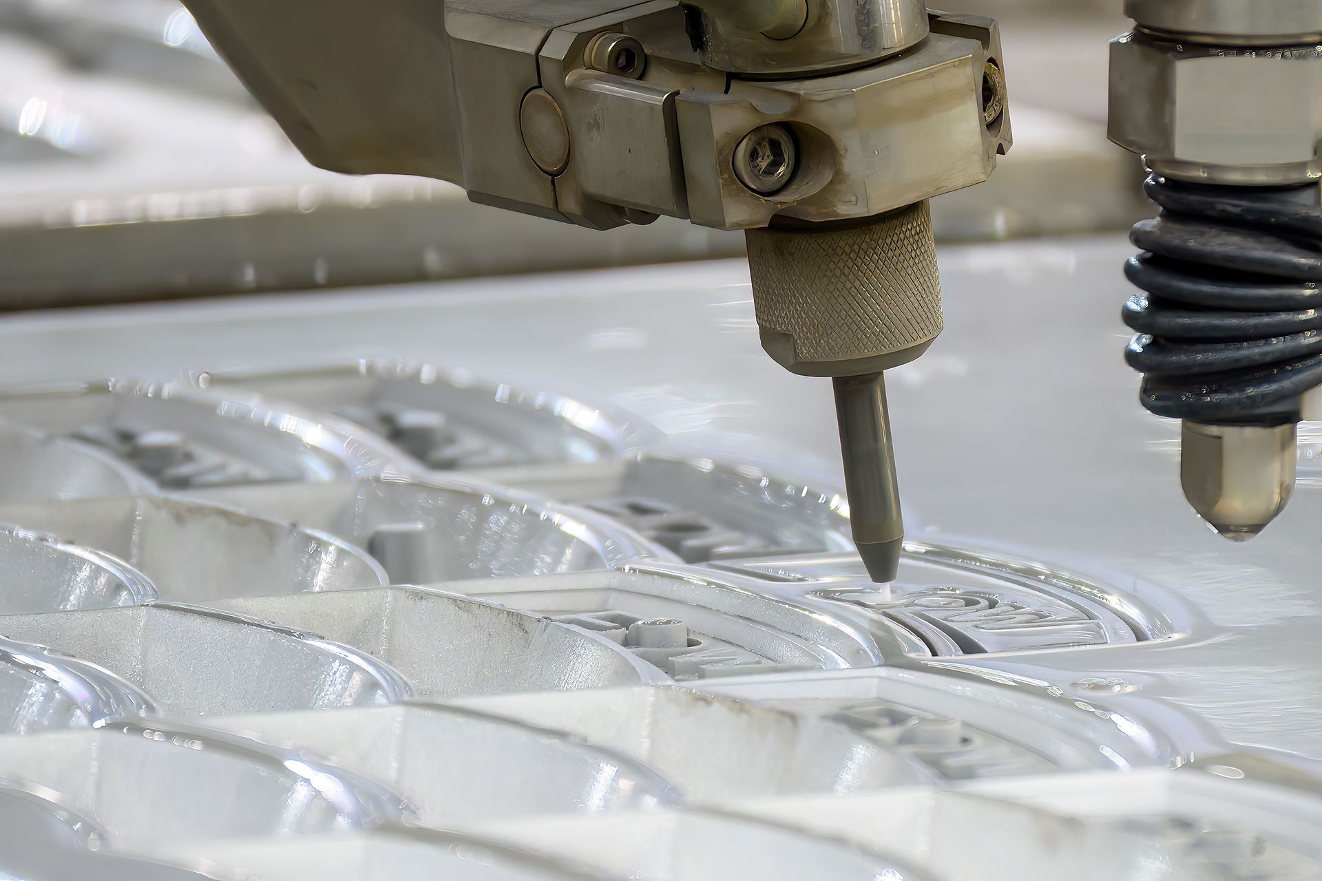 Water jet cutting machine precisely cutting a pattern into a light-colored material.