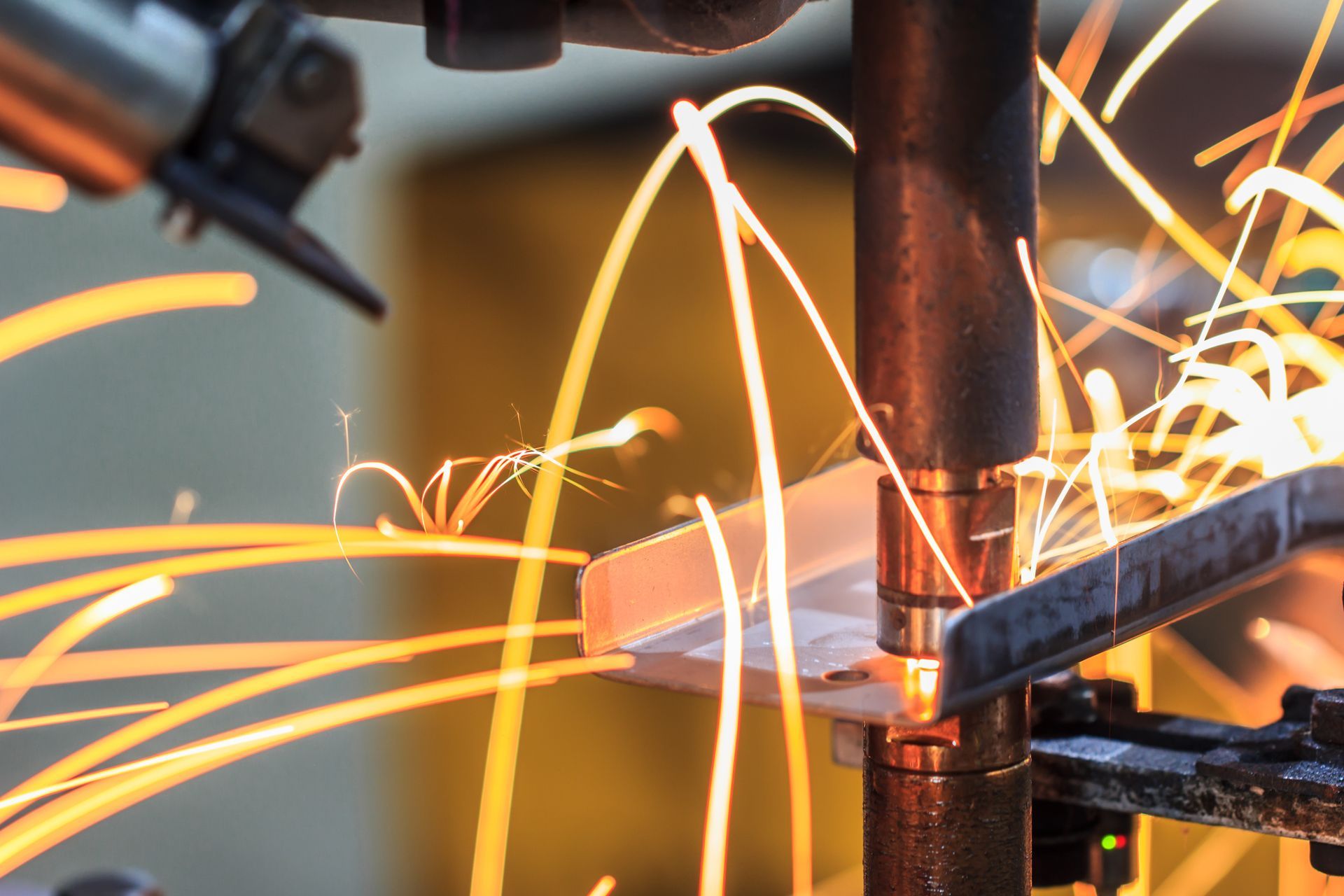 Welding machine in action, emitting sparks, close-up.