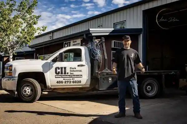 Man stands beside white truck with company logo