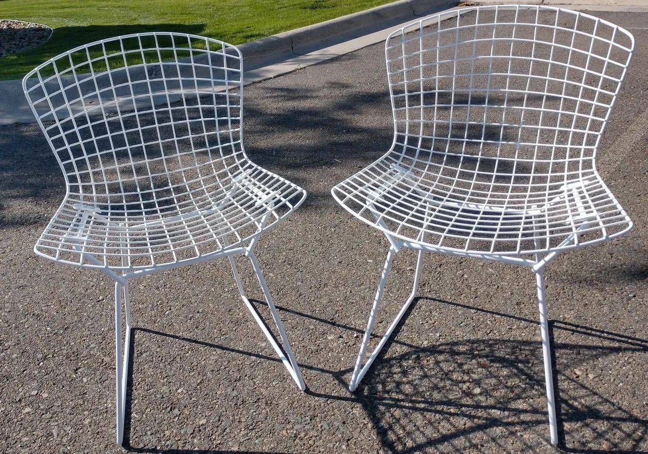 Loft bedroom with black decorative railing and wooden beams. White bedding.