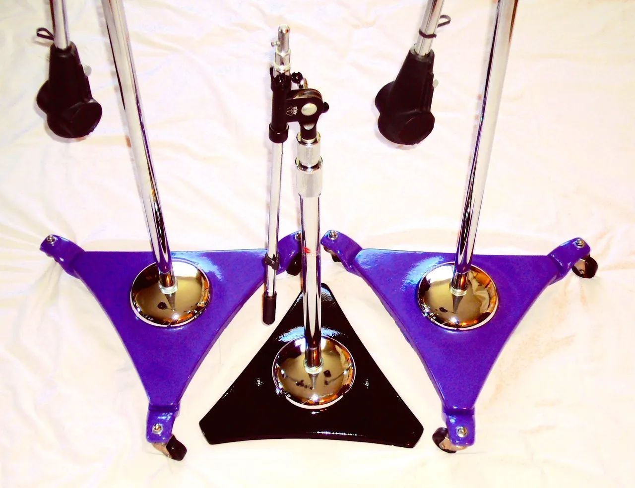Drum hardware: Three stands with blue triangular bases, chrome poles, and black components.