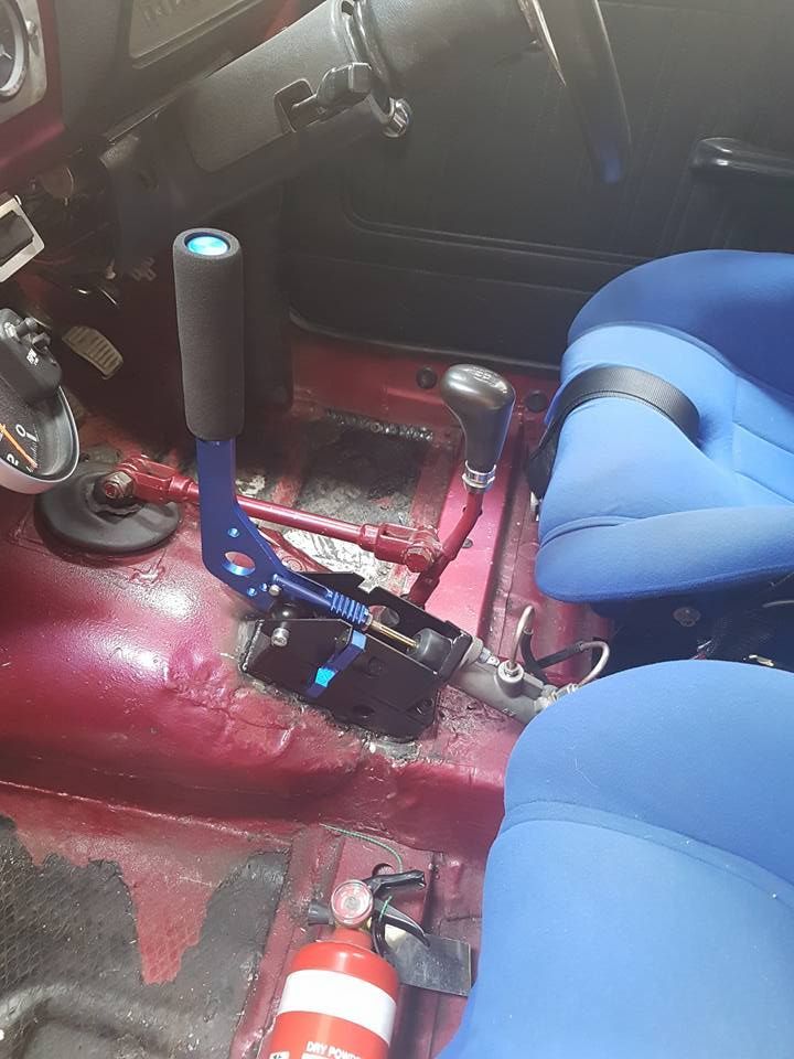 The inside of a car with blue seats and a fire extinguisher.
