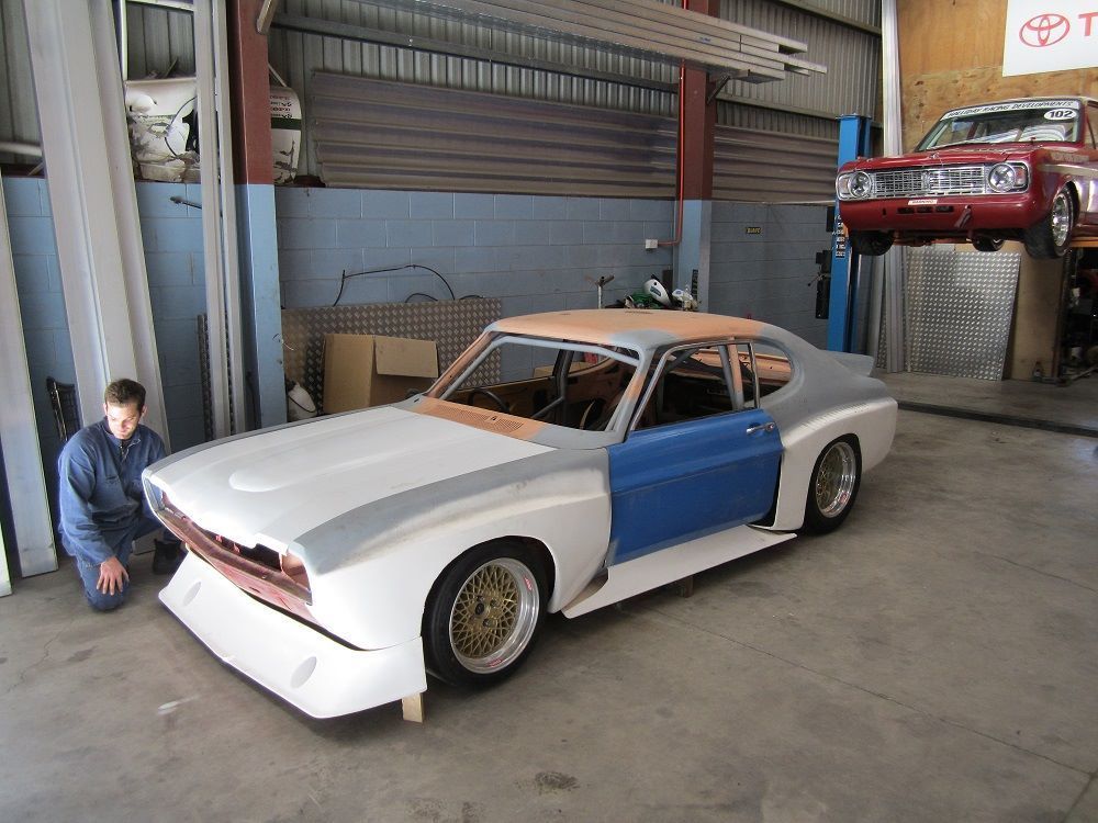 A man is working on a car in a garage.