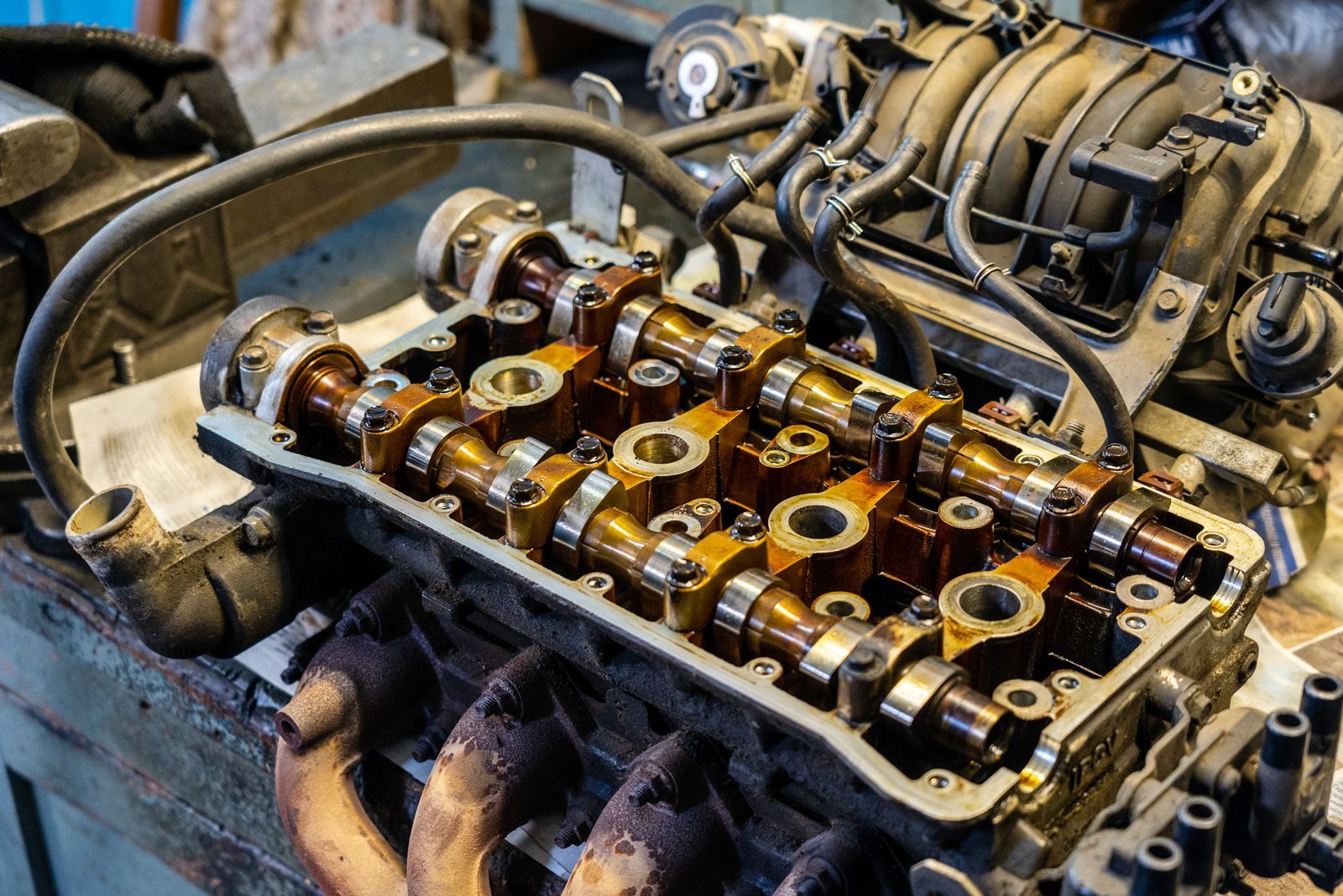 A close up of a car engine being worked on in a garage.