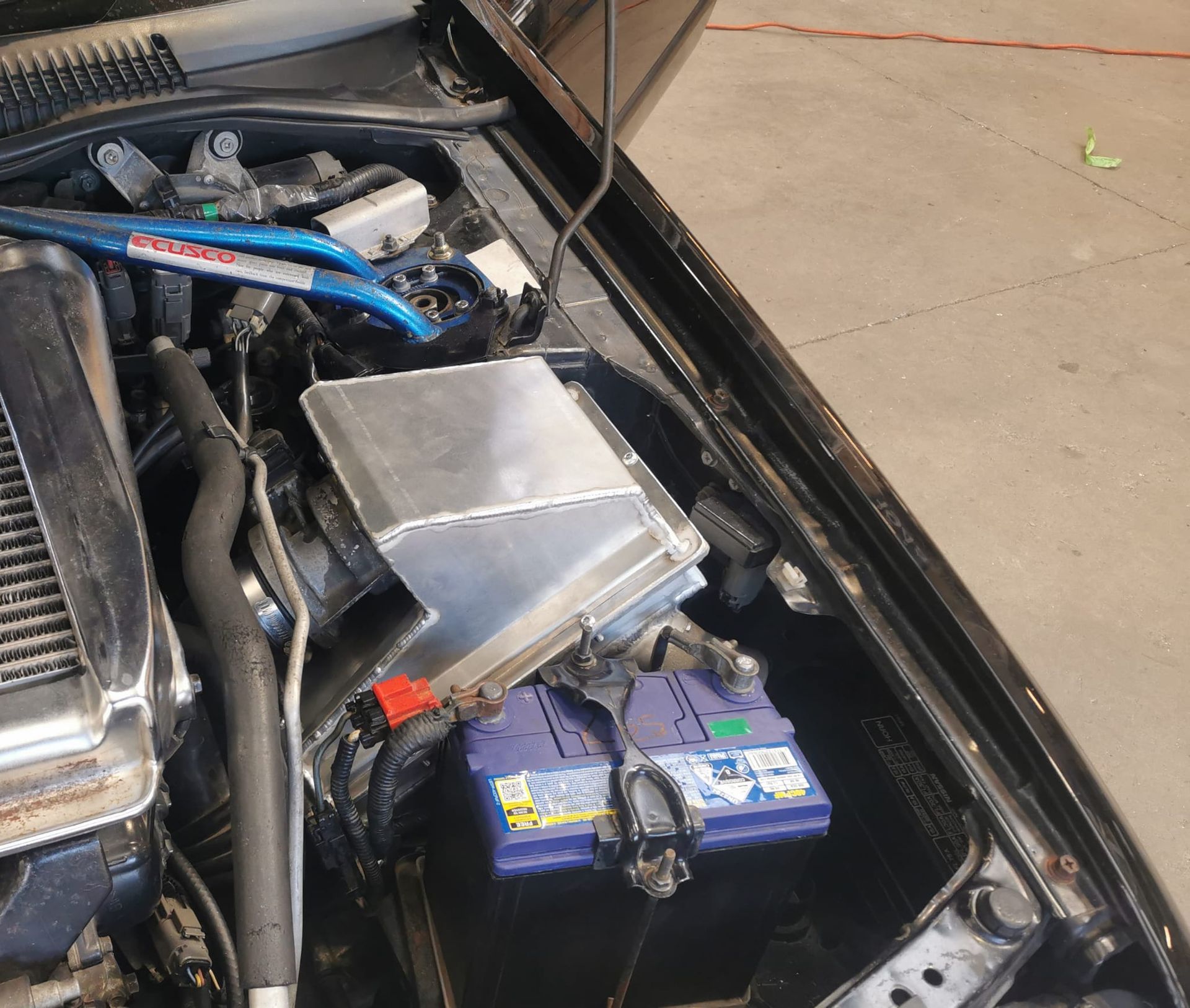 A white car is sitting on a lift in a garage.