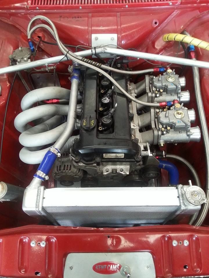 A close up of a red car engine with a radiator.