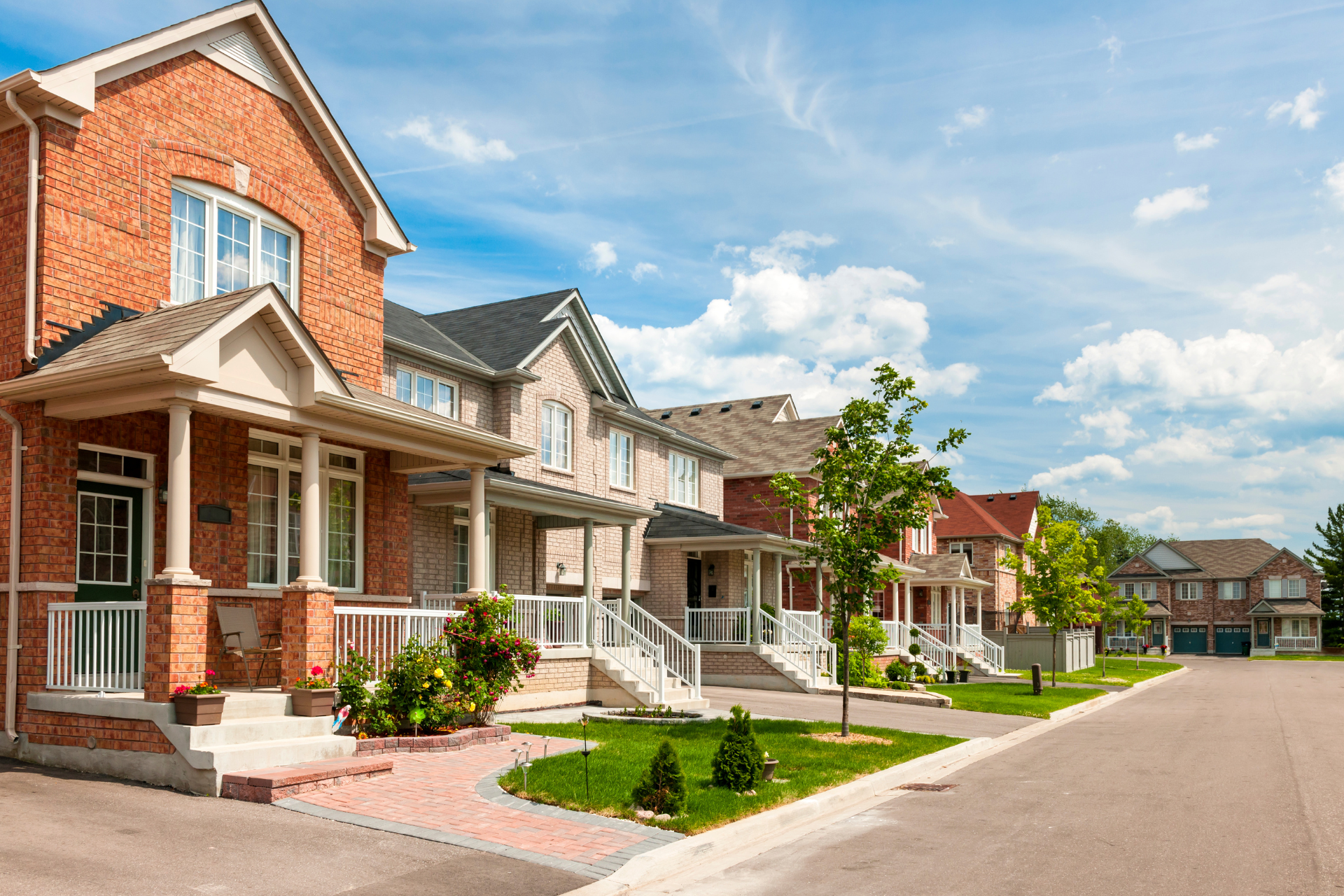 A row of houses in a residential neighborhood on a sunny day.