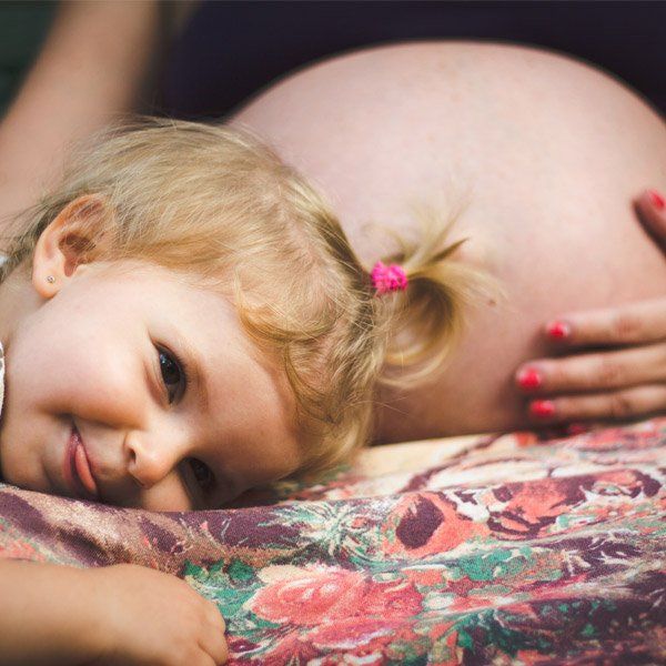 toddler next to pregnant mother