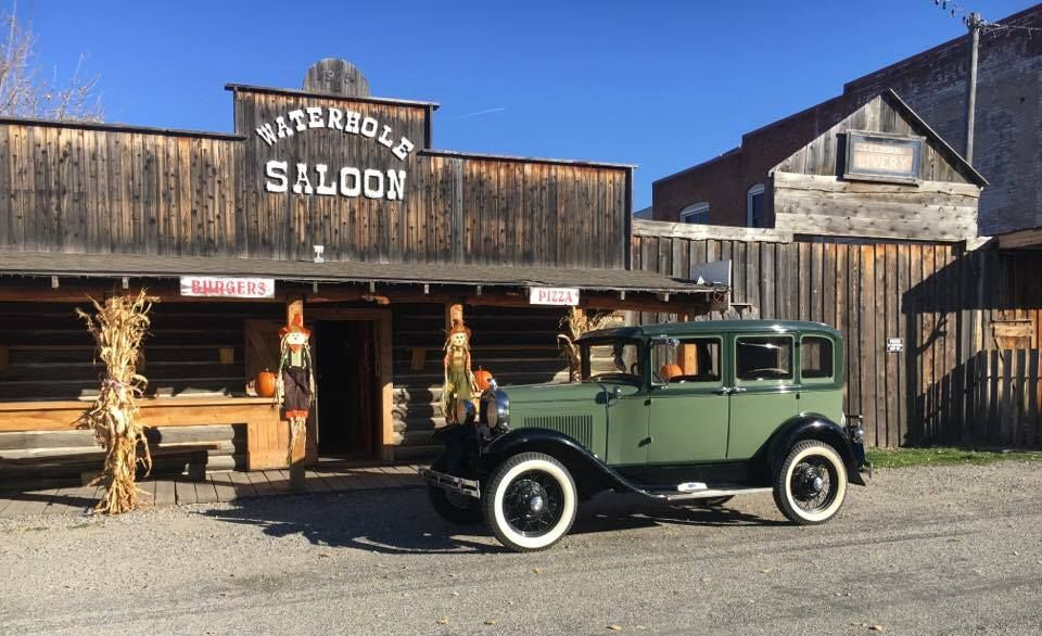 Green classic car parked in front of 