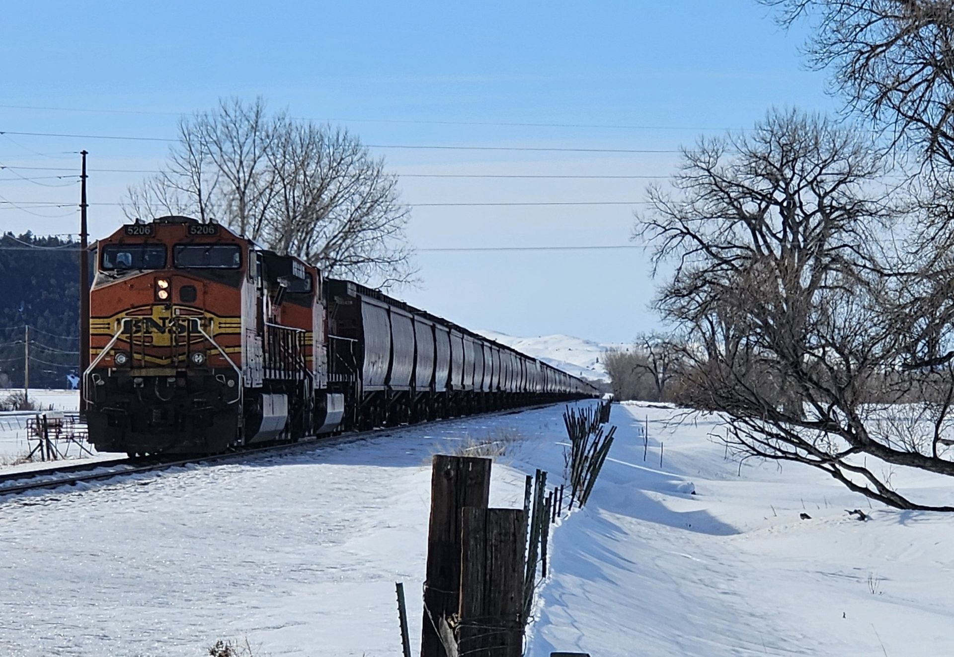 A train is going down the tracks in the snow