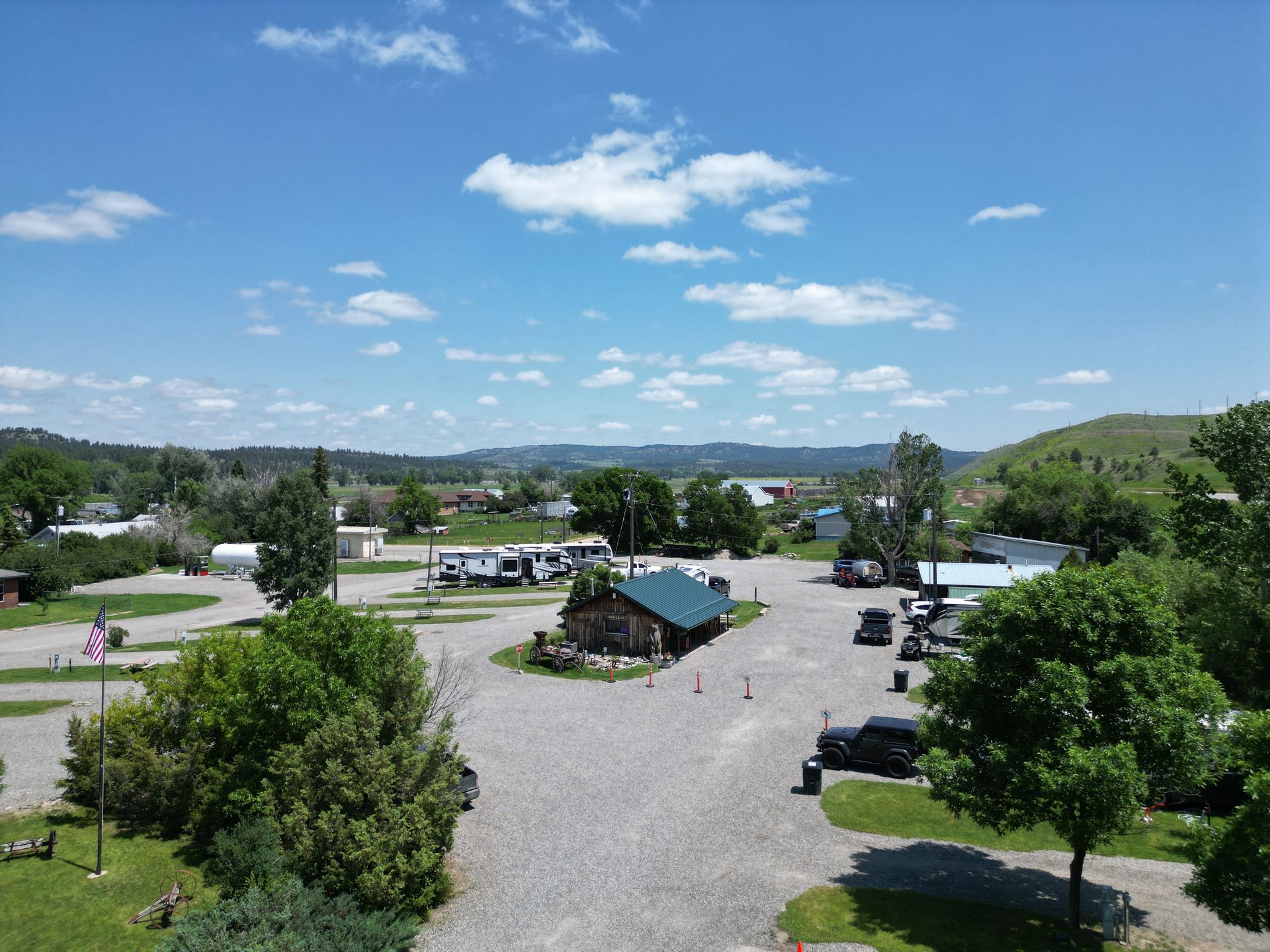 A large grassy field with trees and a fence in the background.