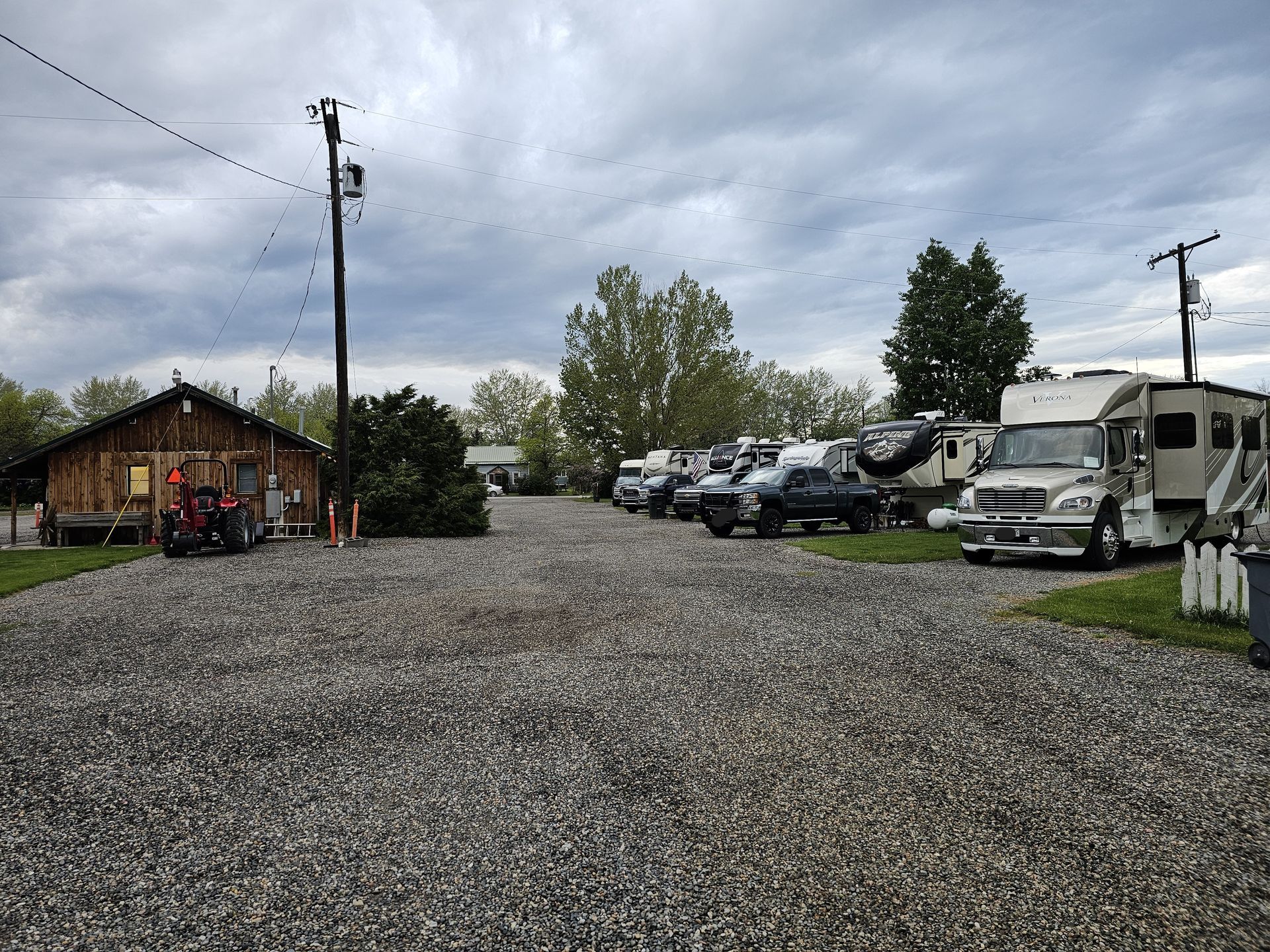 A lot of rv 's are parked in a gravel lot.