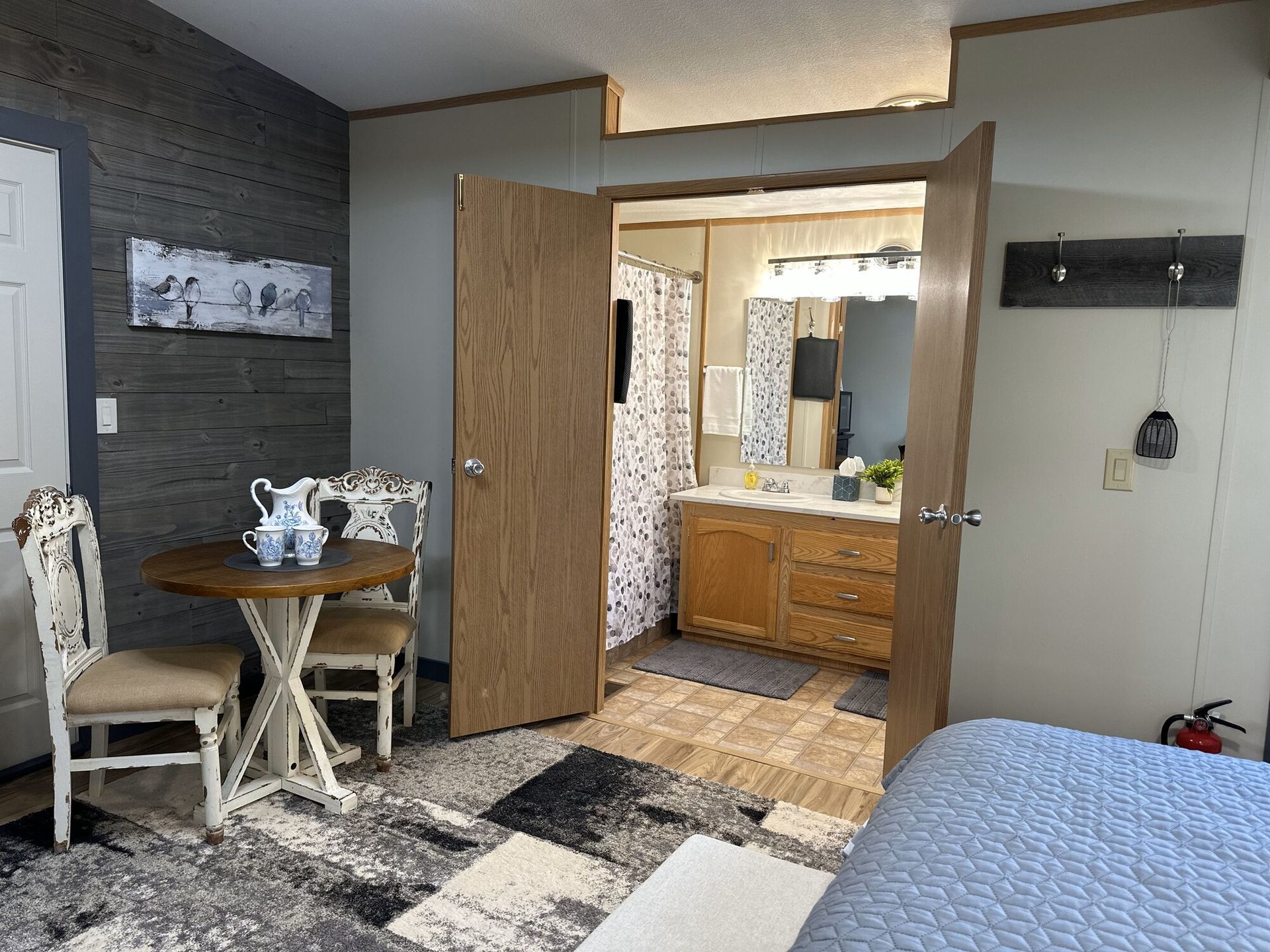 A bedroom with a table and chairs and a bathroom.