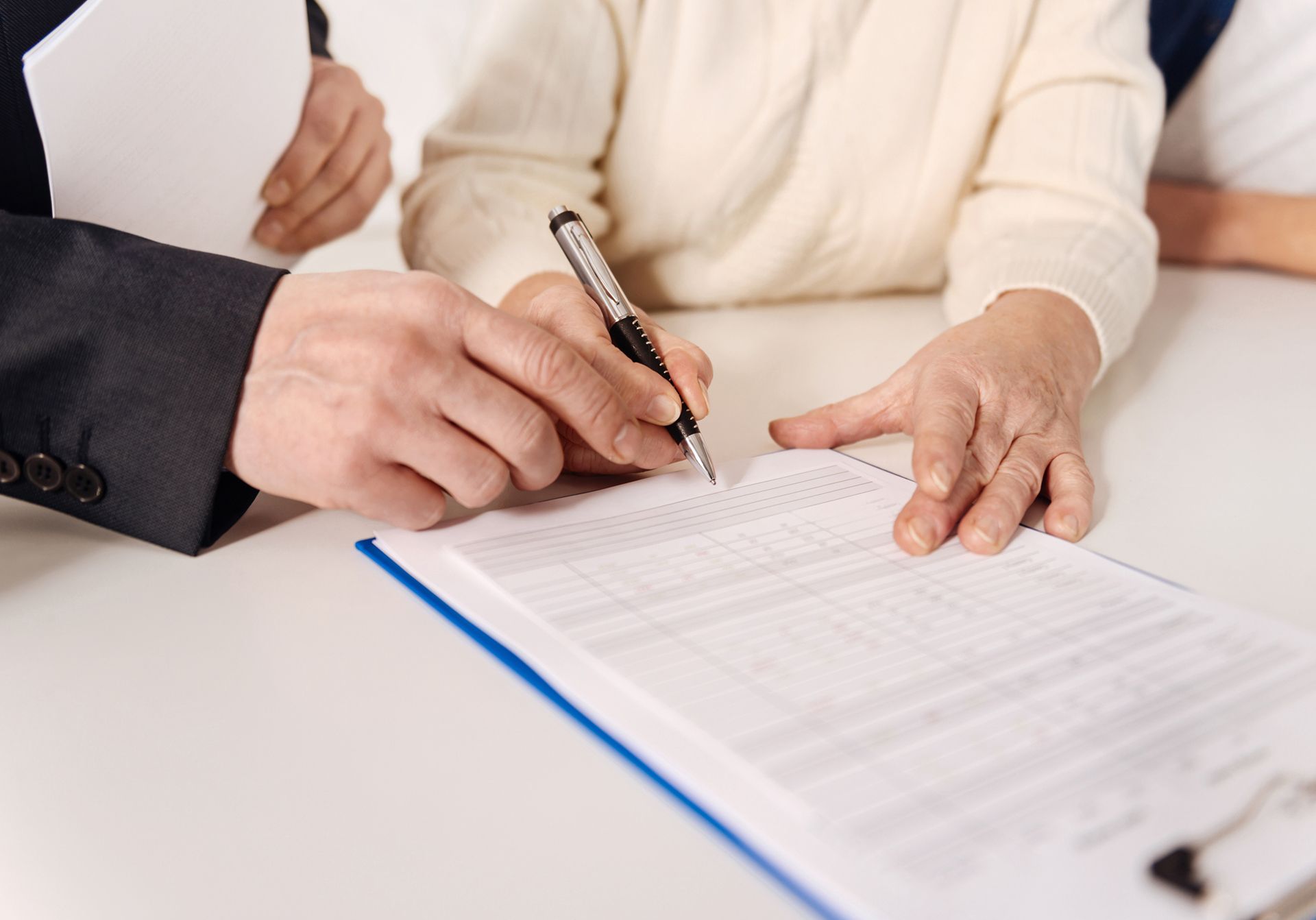Competent social security disability claim advisor helping seniors sign paperwork.