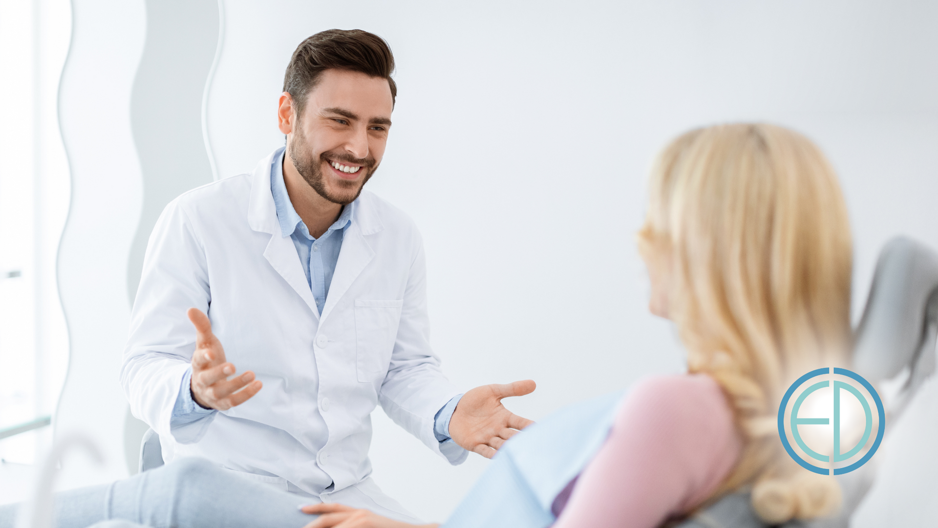 A doctor is talking to a patient in a dental chair.