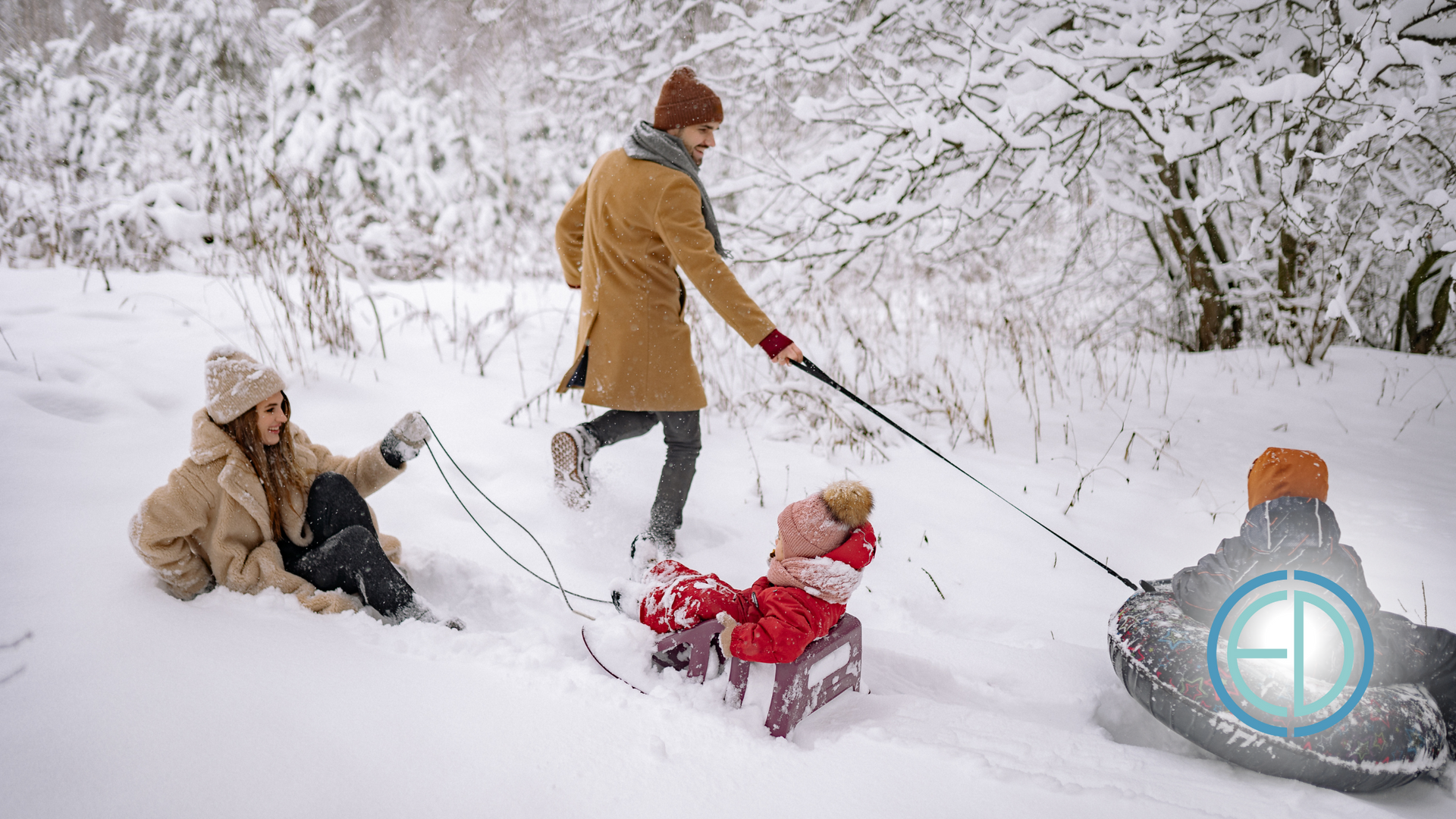 A man is pulling a child on a sled in the snow.