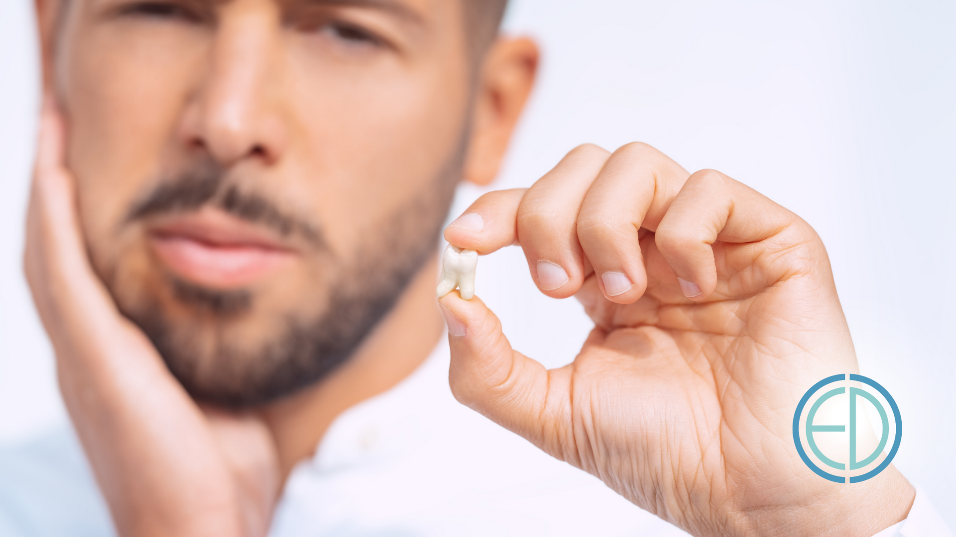 A man is holding a tooth in his hand and has a toothache.