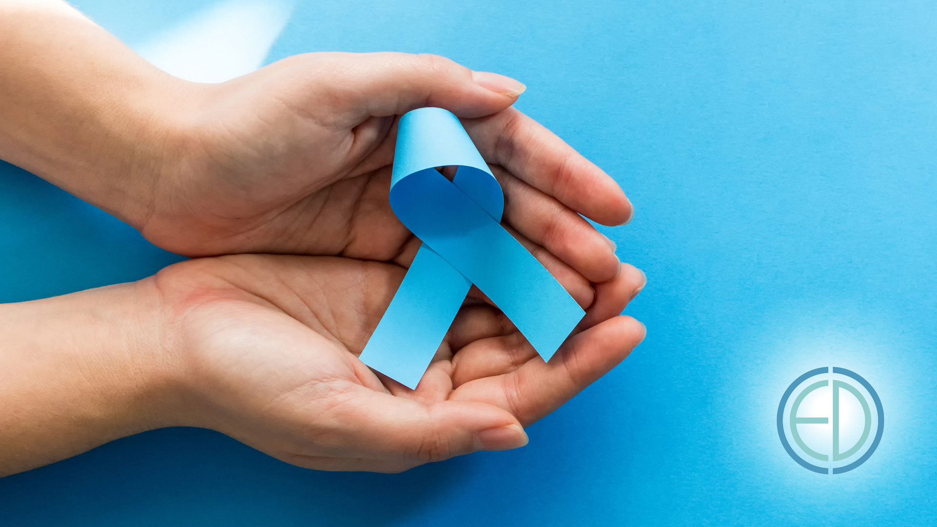 A person is holding a blue ribbon in their hands.